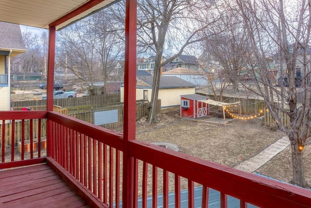 deck with an outbuilding, a fenced backyard, a residential view, and a storage shed