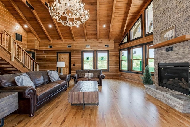 living area featuring wooden ceiling, a fireplace, light wood-style flooring, and wooden walls