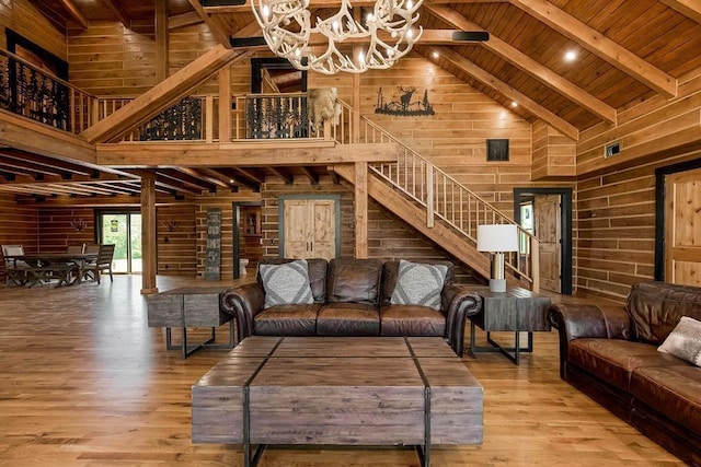 living room with wood ceiling, wooden walls, beam ceiling, and wood finished floors