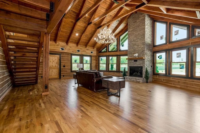 living area featuring wooden ceiling, wood finished floors, an inviting chandelier, a fireplace, and beam ceiling