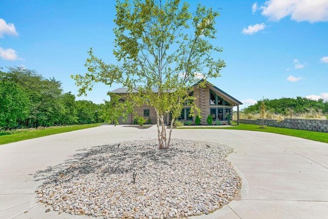 view of front of property featuring curved driveway and log siding