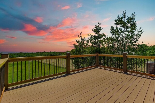 deck at dusk with central AC unit and a lawn