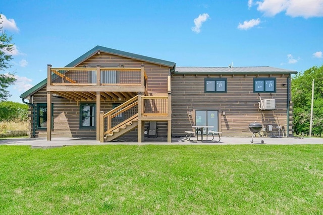 back of property featuring a lawn, stairway, a patio area, metal roof, and a deck