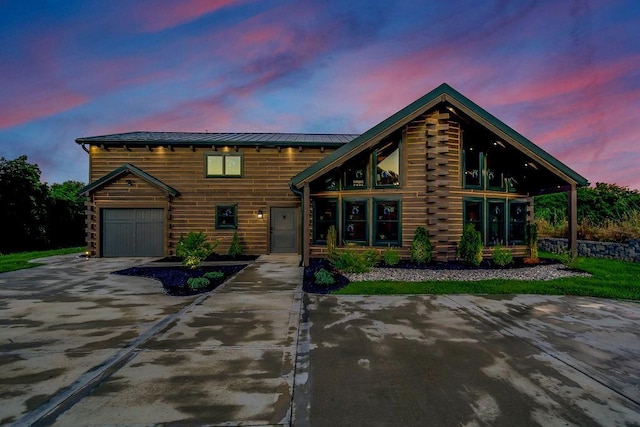 log cabin with concrete driveway, a standing seam roof, metal roof, log siding, and a garage