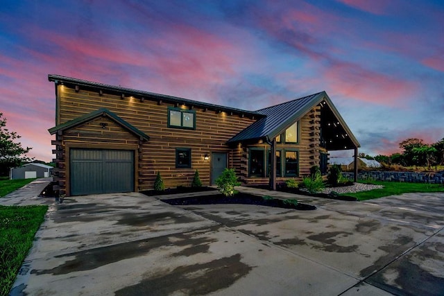 cabin featuring concrete driveway, a standing seam roof, metal roof, log siding, and a garage