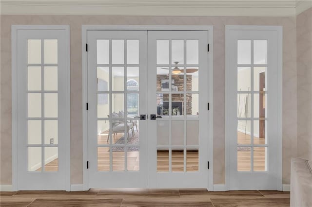 doorway with french doors, wood finished floors, and ornamental molding