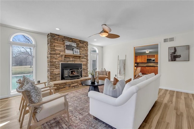 living area featuring baseboards, visible vents, and light wood-type flooring