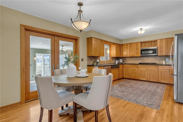 dining area featuring plenty of natural light, french doors, and light wood-style floors