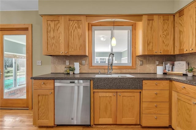 kitchen with tasteful backsplash, a sink, hanging light fixtures, and stainless steel dishwasher