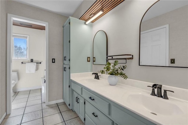 full bathroom featuring a sink, toilet, double vanity, and tile patterned floors