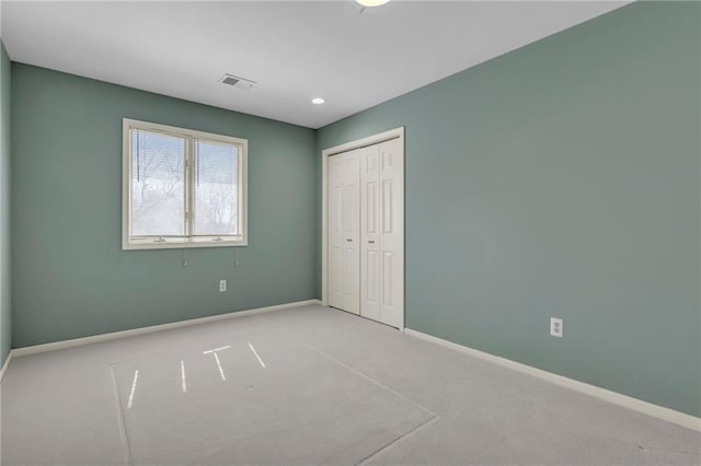 unfurnished bedroom featuring visible vents, baseboards, carpet floors, and a closet