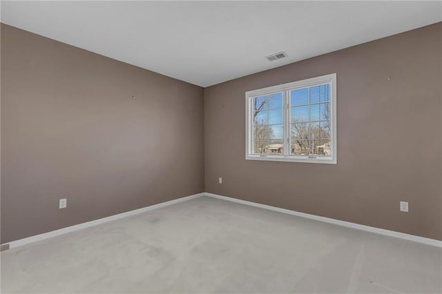 empty room featuring light carpet, visible vents, and baseboards