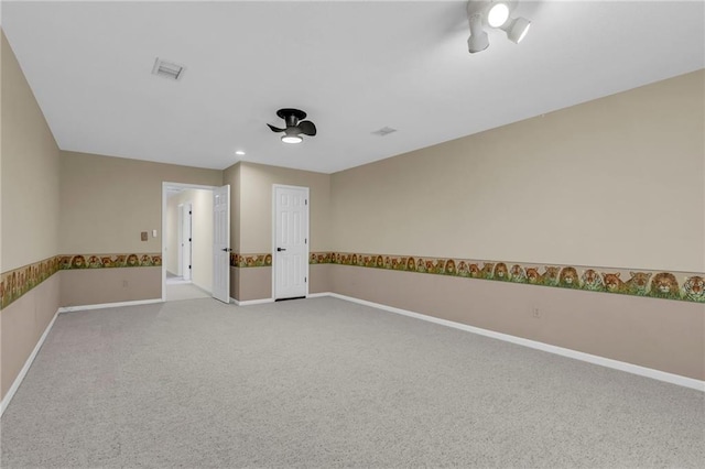 carpeted empty room with a ceiling fan, visible vents, and baseboards