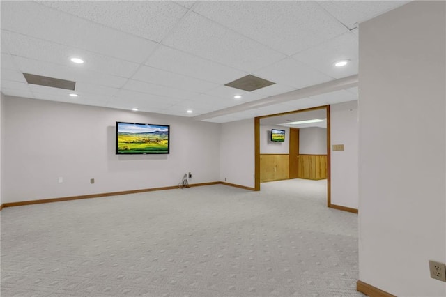 finished basement with recessed lighting, light colored carpet, and wood walls