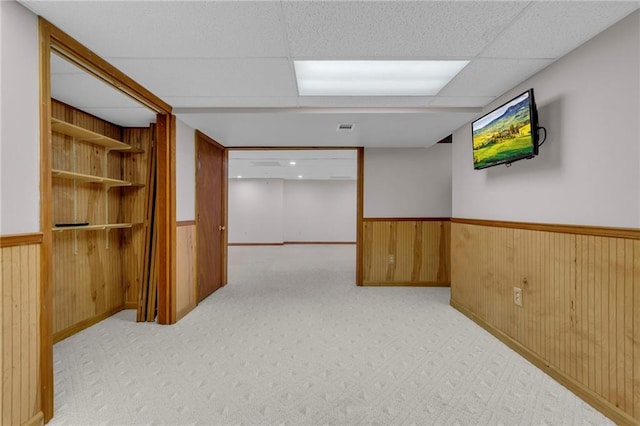 interior space featuring visible vents, wooden walls, wainscoting, and carpet