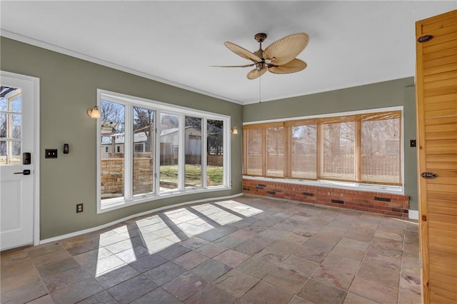 unfurnished sunroom featuring ceiling fan