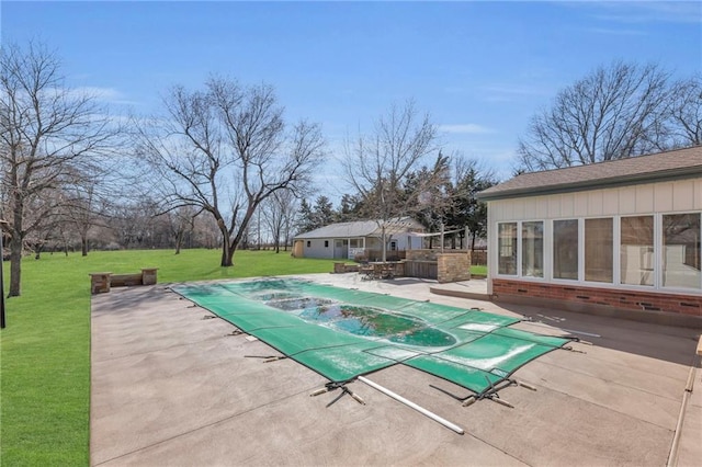 view of swimming pool featuring a covered pool, a lawn, and a patio area