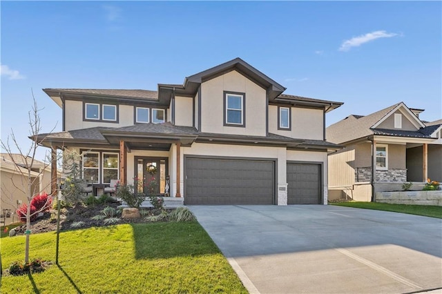 prairie-style home with driveway, a front lawn, an attached garage, and stucco siding