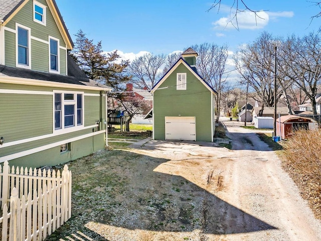 view of yard with dirt driveway and fence