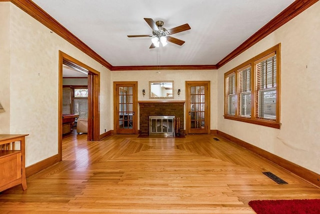 living area featuring baseboards, a fireplace, visible vents, and crown molding