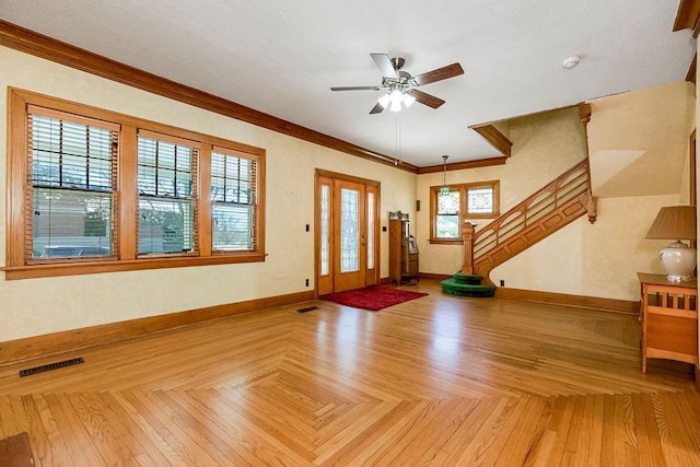 entrance foyer with baseboards, stairs, visible vents, and crown molding