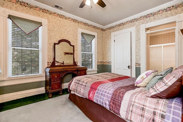 bedroom featuring ceiling fan, visible vents, baseboards, ornamental molding, and carpet