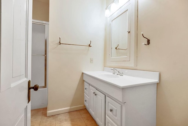 bathroom featuring baseboards, enclosed tub / shower combo, vanity, and tile patterned floors