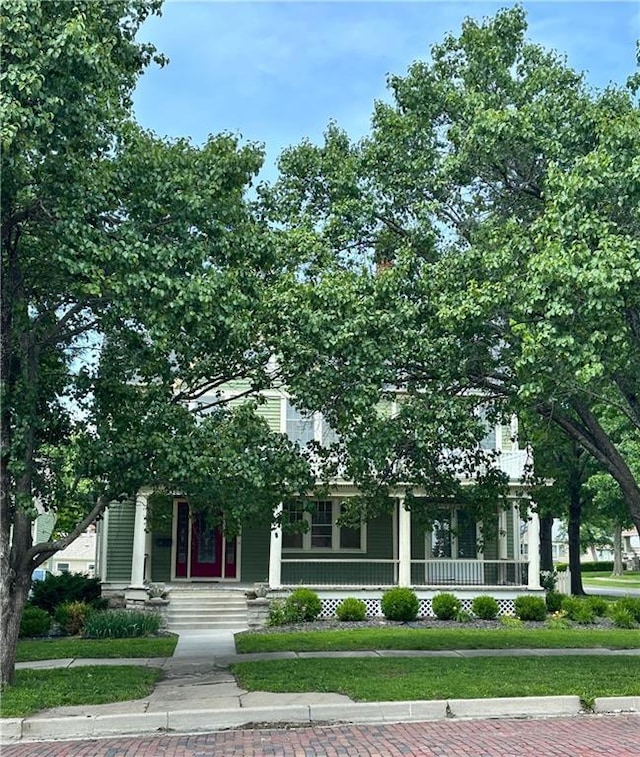 510 E Chippewa St, Paola, KS 66071 - view of property hidden behind natural elements featuring a porch and a front lawn