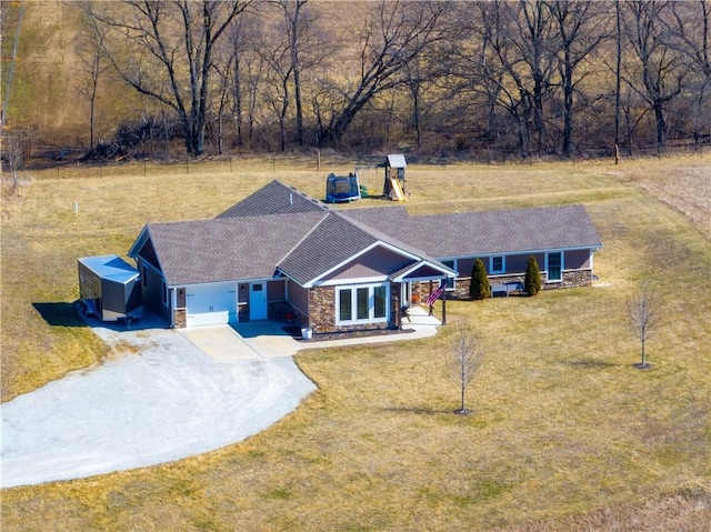 view of front of home with a front yard, stone siding, driveway, and an attached garage