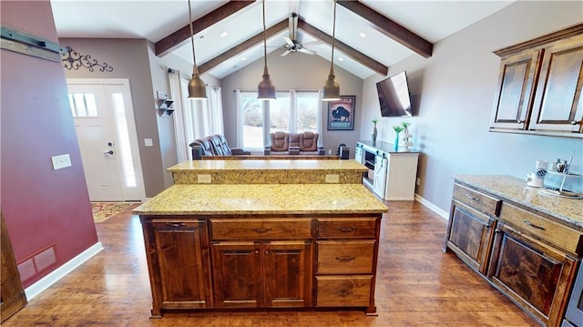 kitchen with decorative light fixtures, vaulted ceiling with beams, wood finished floors, visible vents, and light stone countertops