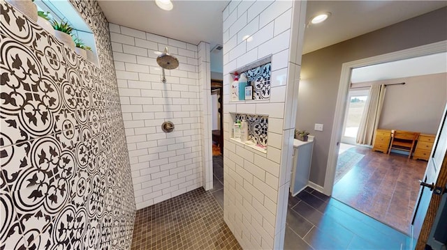 bathroom featuring tiled shower and tile patterned flooring