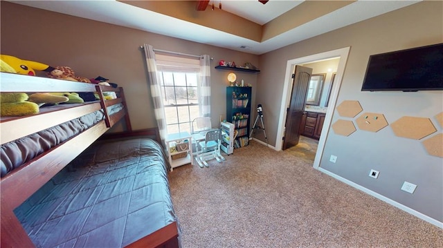 carpeted bedroom featuring ceiling fan, baseboards, and connected bathroom