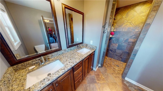 bathroom with baseboards, walk in shower, and a sink