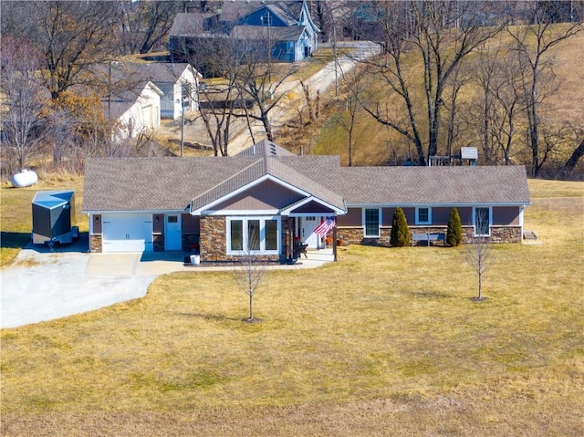 single story home with a garage, stone siding, driveway, and a front lawn