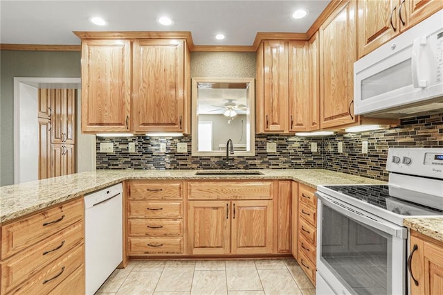 kitchen with ceiling fan, light stone counters, decorative backsplash, white appliances, and a sink