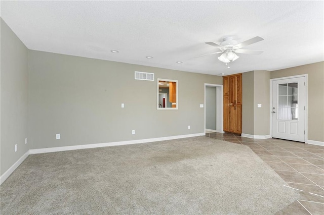 unfurnished living room with visible vents, ceiling fan, baseboards, light carpet, and a textured ceiling