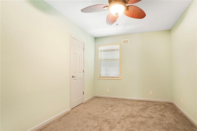 unfurnished room with a ceiling fan, visible vents, baseboards, and light carpet