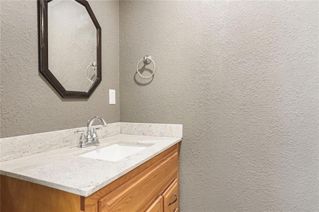 bathroom featuring vanity and a textured wall