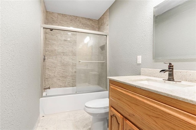 bathroom featuring shower / bath combination with glass door, toilet, vanity, and a textured wall