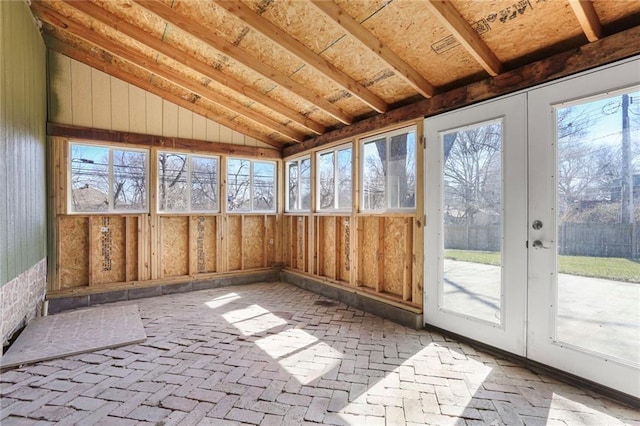 unfurnished sunroom featuring vaulted ceiling