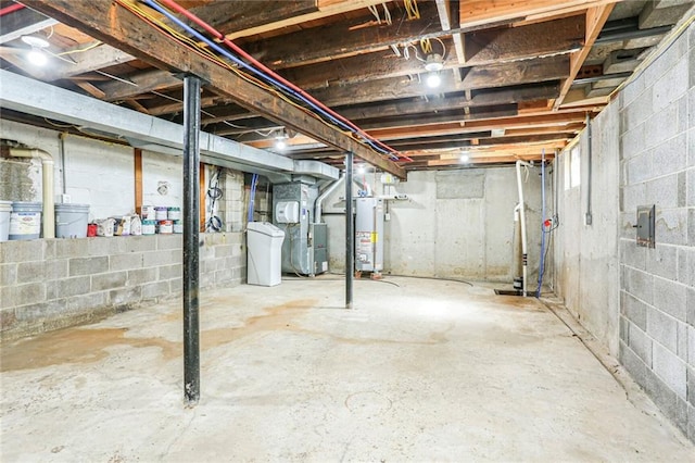 unfinished basement featuring gas water heater and heating unit