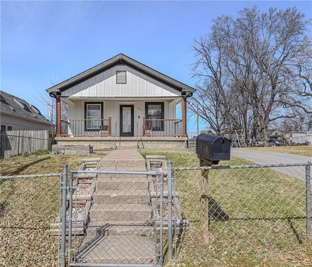 bungalow-style home with board and batten siding, a gate, covered porch, and a fenced front yard