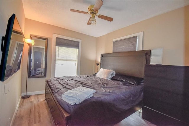 bedroom featuring ceiling fan, baseboards, and wood finished floors