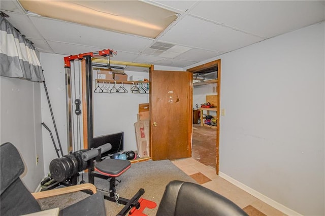 workout room with baseboards and a drop ceiling