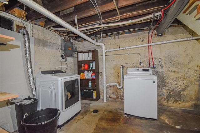 unfinished basement featuring electric panel and separate washer and dryer