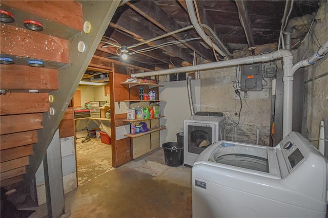 unfinished below grade area featuring electric panel and separate washer and dryer