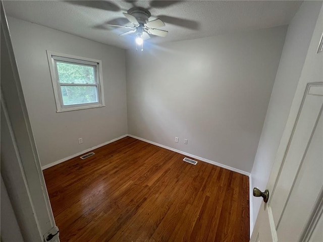 empty room featuring visible vents, a textured ceiling, baseboards, and wood finished floors