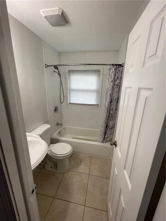 bathroom with toilet, a textured ceiling, shower / bath combo, and visible vents