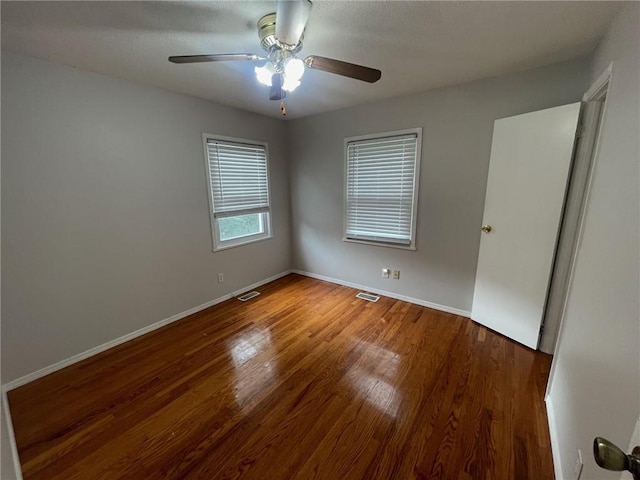 unfurnished bedroom featuring visible vents, baseboards, and wood finished floors