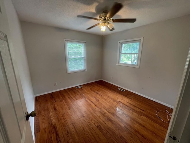 unfurnished bedroom with visible vents, baseboards, and wood finished floors